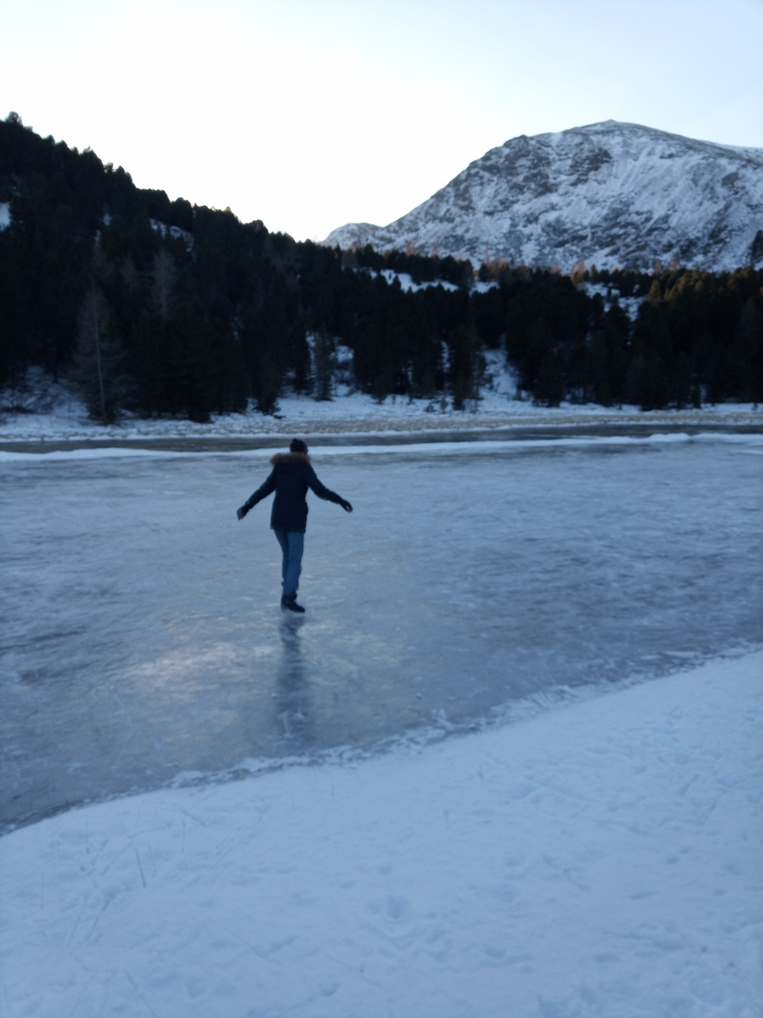 Winterliche Berglandschaft mit einer Person auf einer zugefrorenen Eisfläche